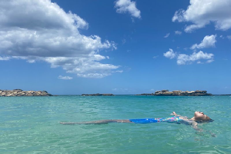 girl floating in beautiful blue ocean water
