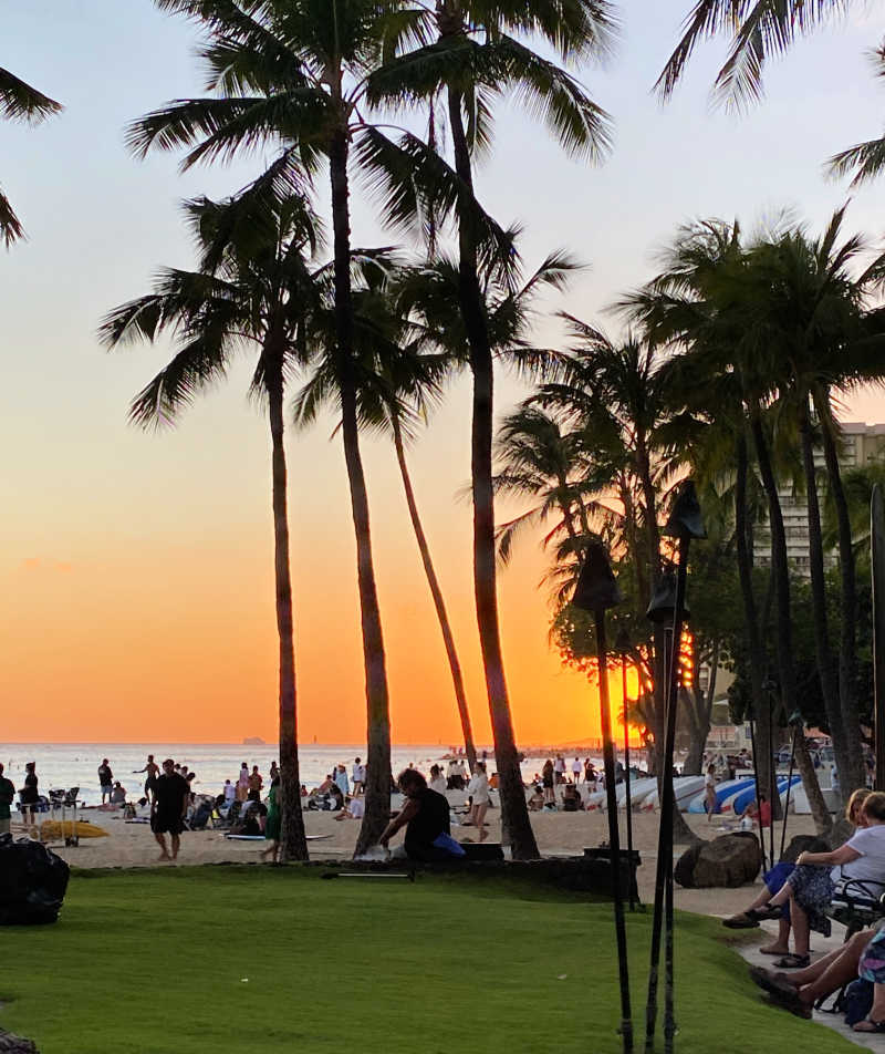 Waikiki beach in Oahu at sunset is a popular place with tourists