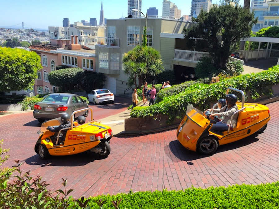 Many tourists enjoy either walking or driving down Lombard Street in yellow go-cars 