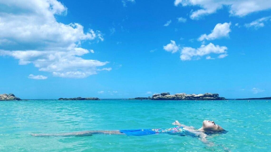 girl floating in beautiful blue water at Lagoons at Ko Olina