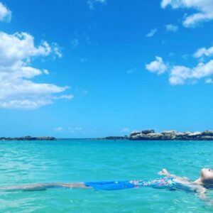 girl floating in beautiful blue water at Lagoons at Ko Olina