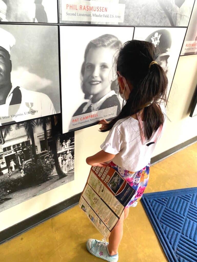 little girl looking at survivor photo at museum