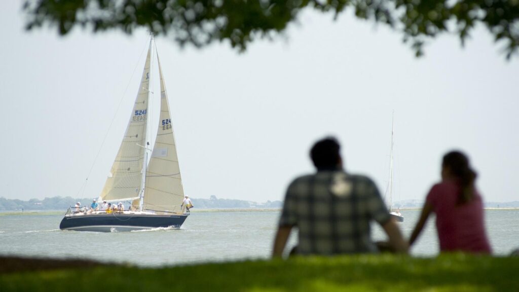 man and woman watching sail boat go by
