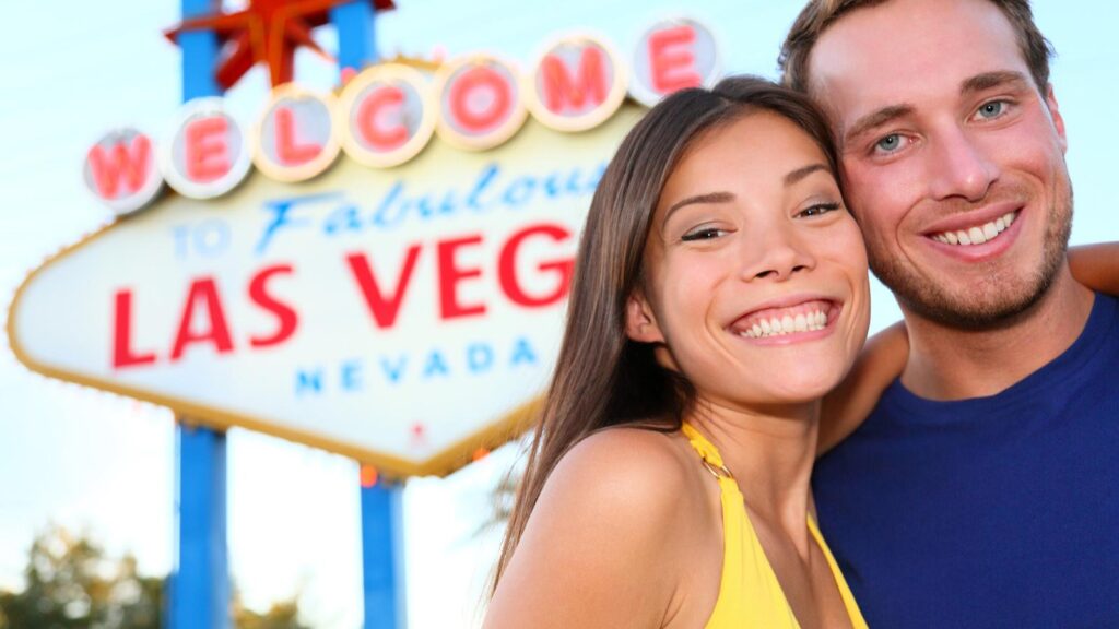 mand and woman in front of Las Vegas sign