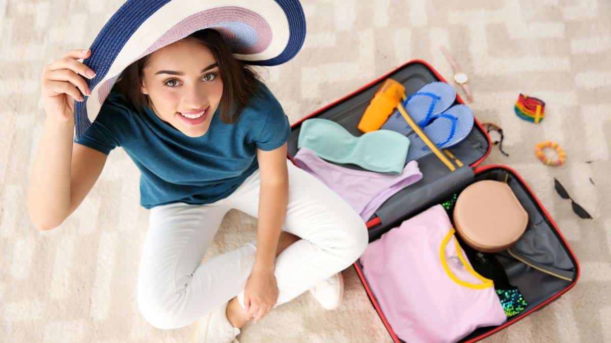 woman smiling packing suitcase