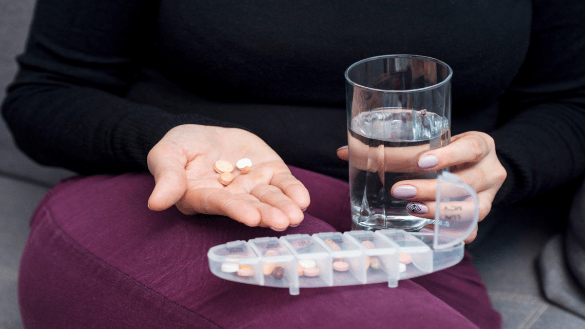 Andrii-Zorii-Woman-holds-tablet-and-glass-of-water.-Female-going-to-take-tablet-from-headache-or-painkiller-or-abortion-pill-medication-drinking-clear-water-from-glass.png