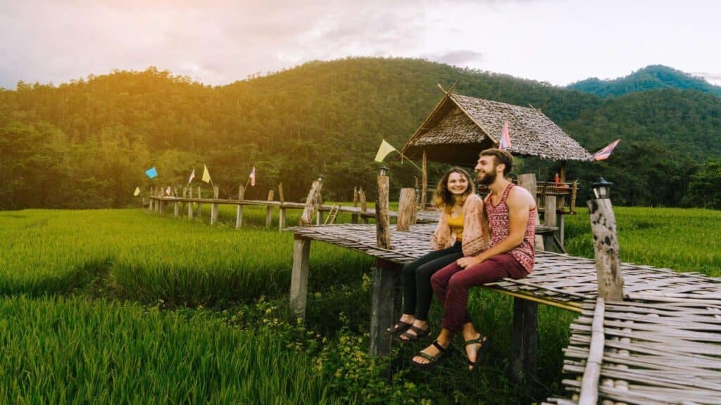Young Caucasiasn couple on the bamboo bridge near rice field, Thailand