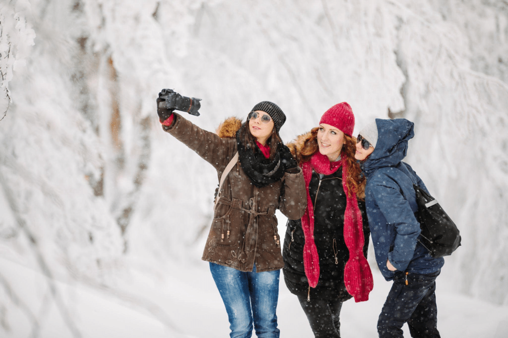 bojanstory - Three female friends taking selfie in nature at snowy winter day
