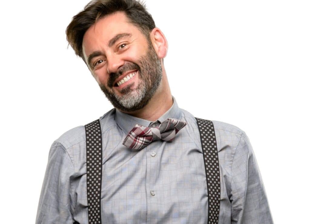 Middle age man, with beard and bow tie confident and happy with a big natural smile laughing, natural expression
