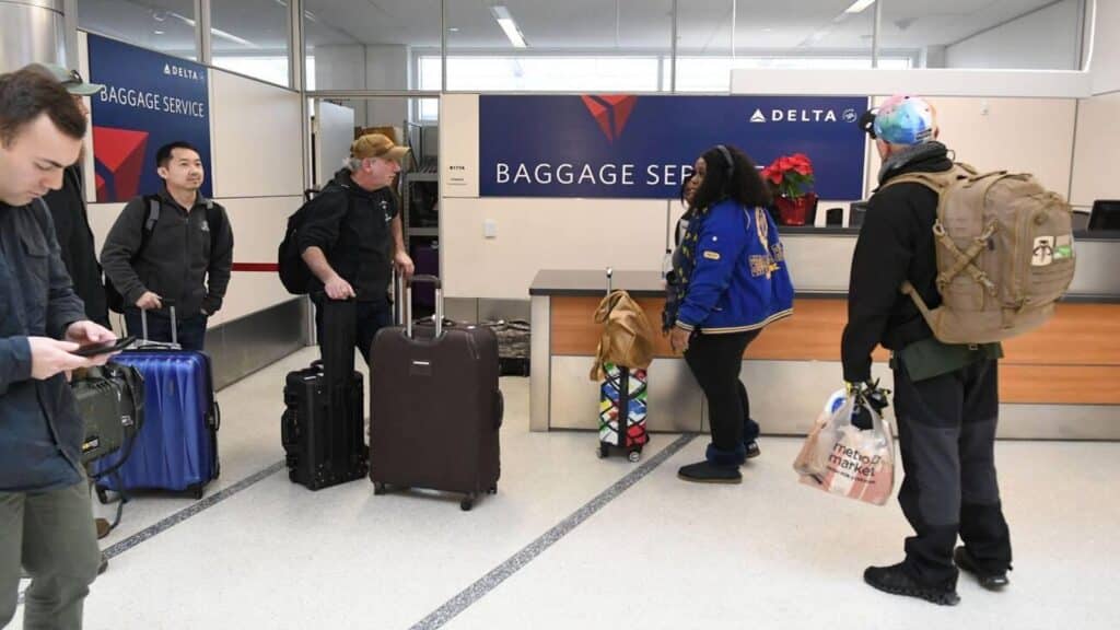 Passengers queue at the Delta Airlines baggage service counter at Milwaukee Mitchell International Airport in Milwaukee, Wisconsin, (