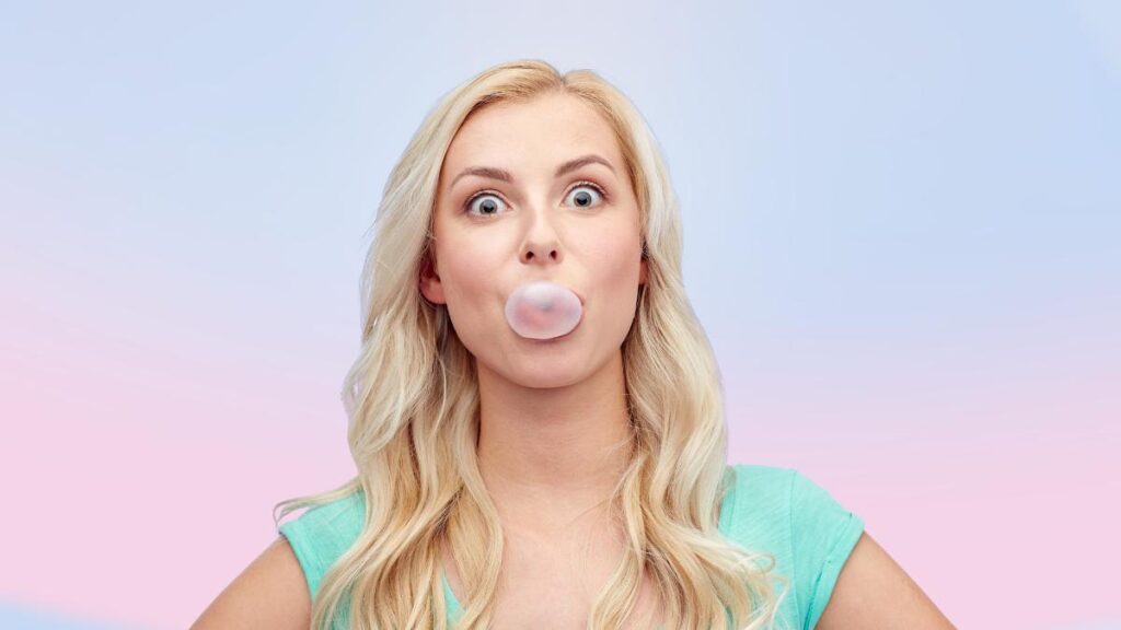 blonde woman blowing bubble gum