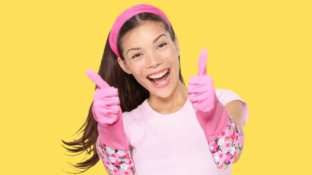 happy cleaning housewife yellow background -