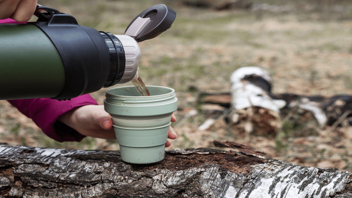 valiantsin suprunovich - Woman hands pouring tea from thermos into mug on nature background