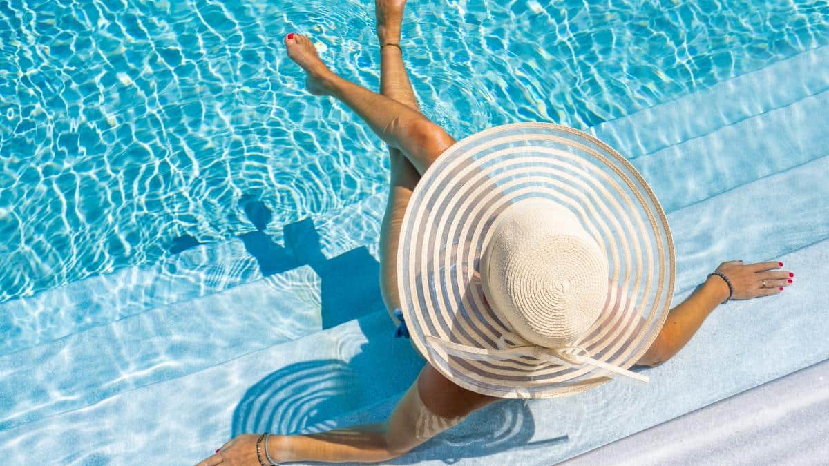 woman in luxury pool with hat