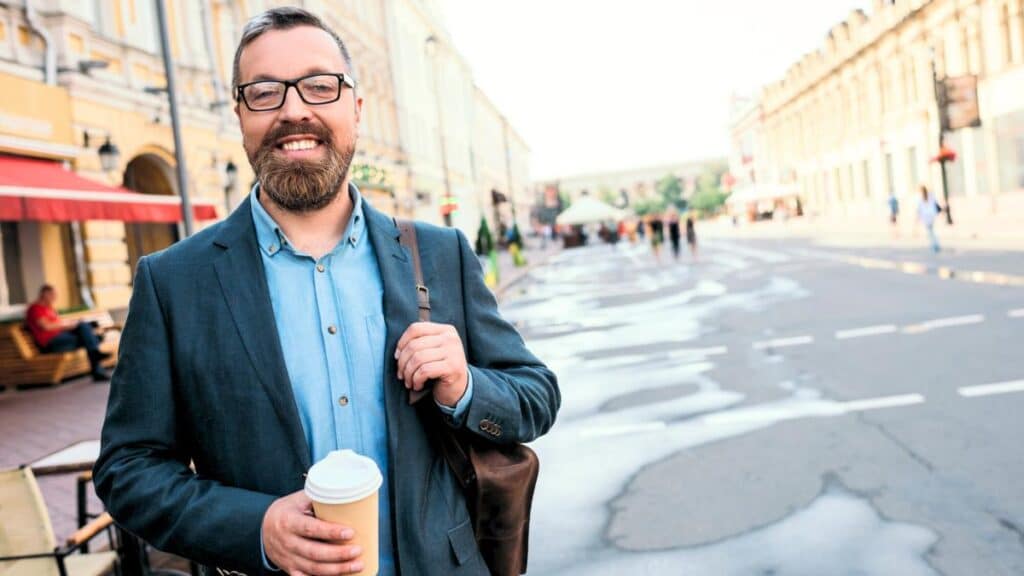 man walking in city with coffee