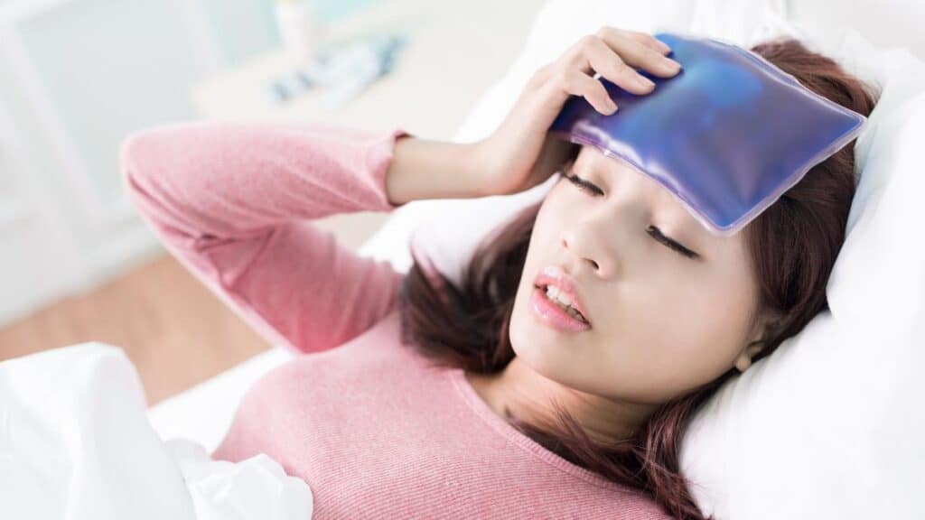 sick woman with ice pack on head