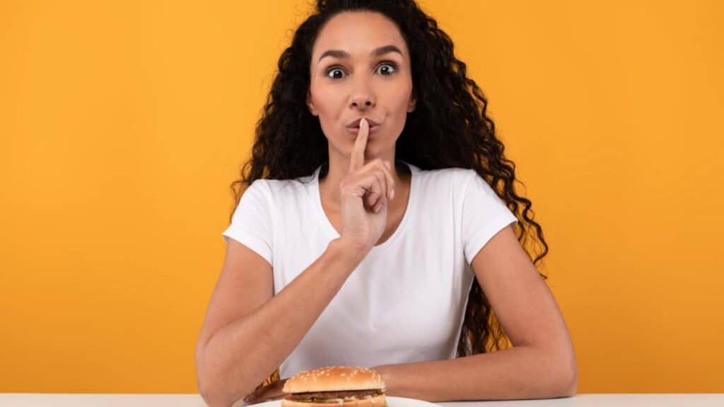 woman secret eating yellow background