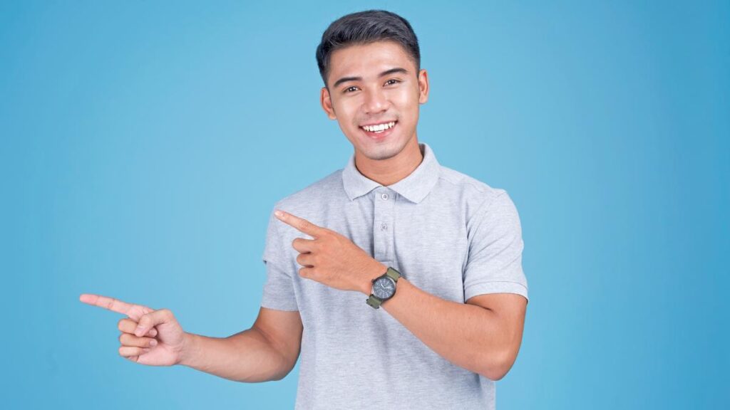 young man pointing blue background - Tunagaga Canva