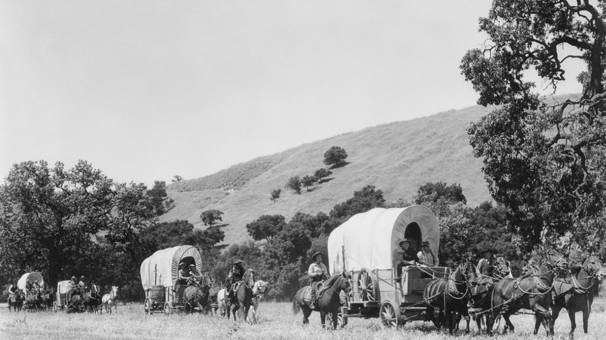 cowboys and pioneers in covered wagons
