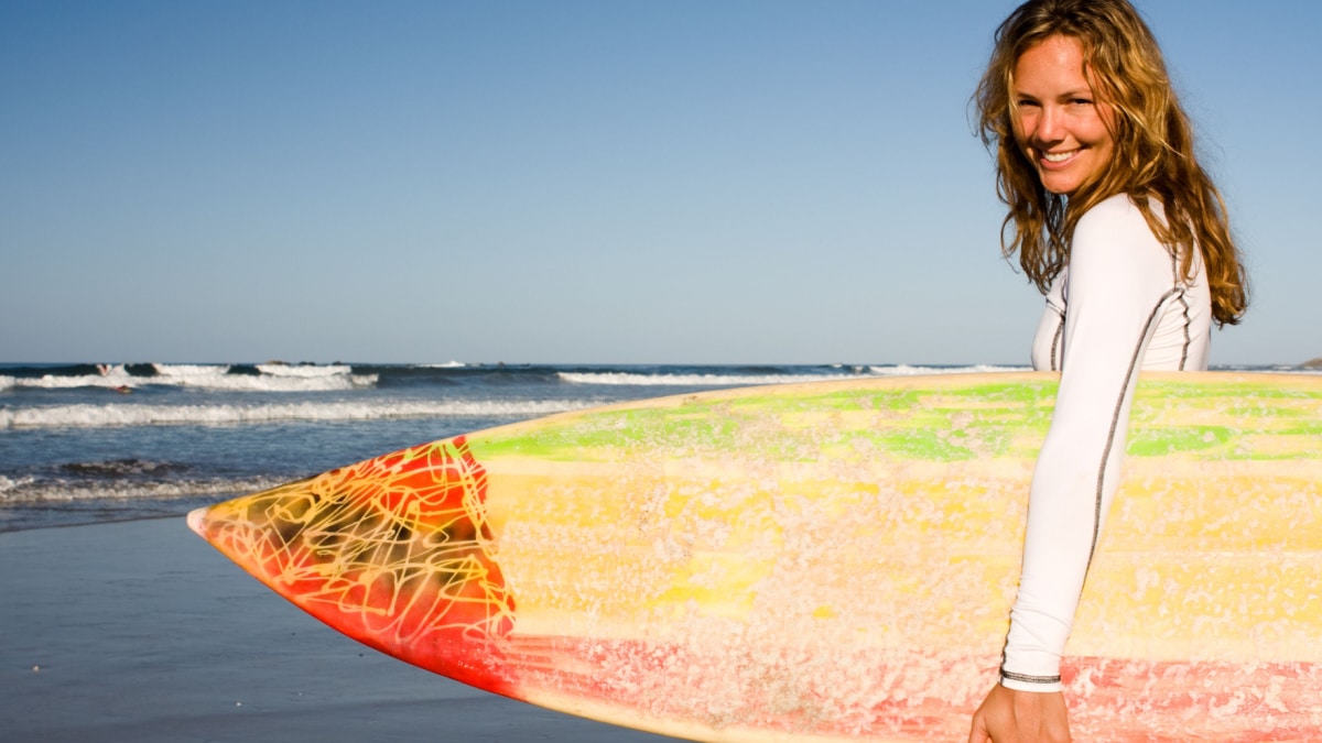 woman at beach with surf board