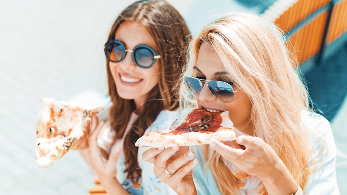 two women eating pizza