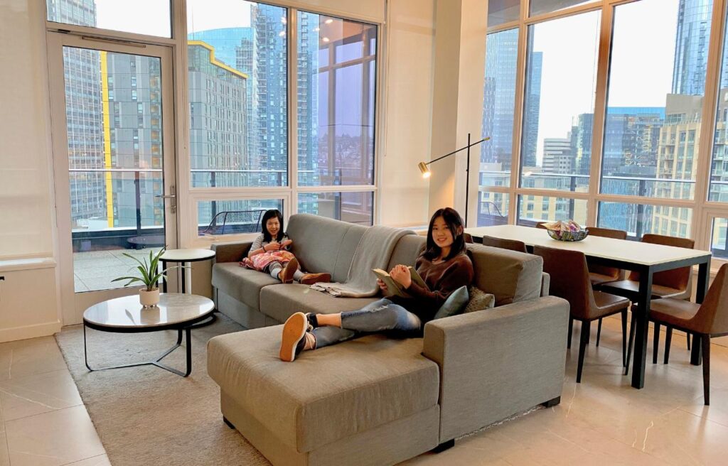 two young girls sitting on couch in hotel room