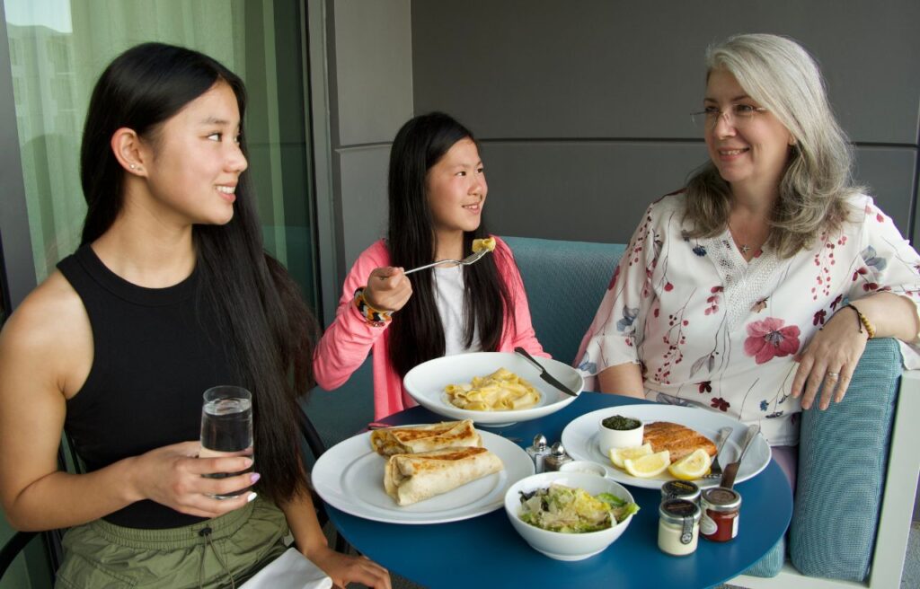 mom and two daughters eating dinner on patio