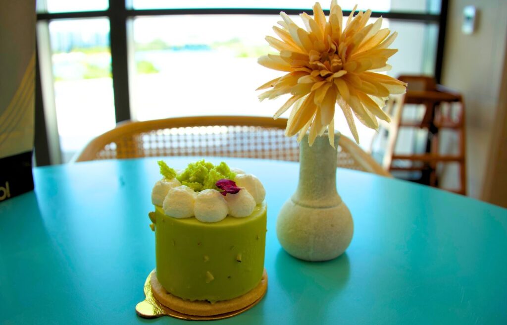 beautiful green pastry treat on table with flower in vase