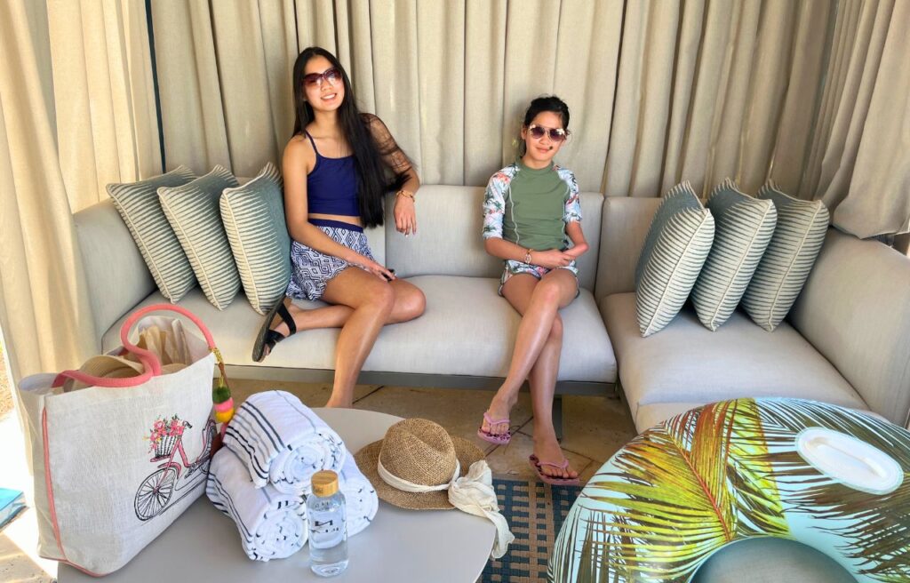 two girls sitting in private poolside cabana