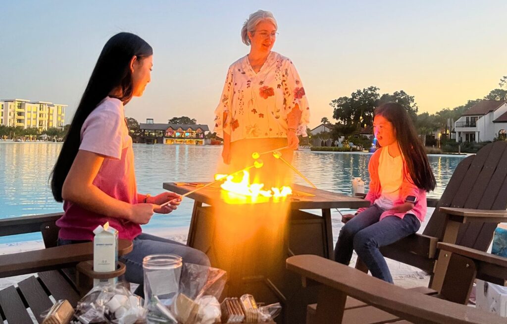 mom and two daughters by campfire